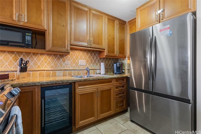 kitchen with black microwave, light tile patterned floors, wine cooler, a sink, and freestanding refrigerator