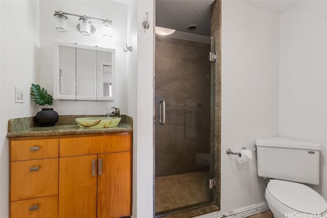 bathroom with vanity, a shower stall, and toilet