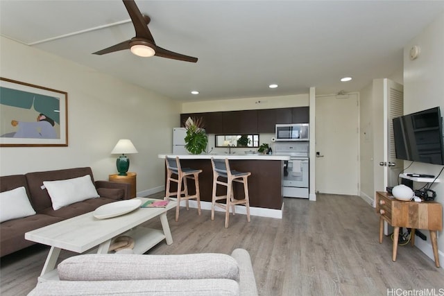 living area featuring recessed lighting, light wood-style floors, baseboards, and ceiling fan