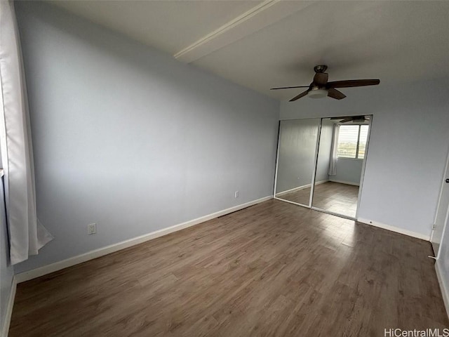 unfurnished bedroom with ceiling fan, a closet, baseboards, and wood finished floors