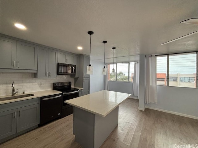 kitchen featuring black appliances, light countertops, a sink, and gray cabinetry