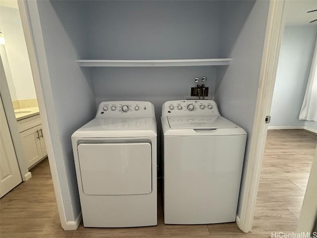 laundry room featuring light wood-type flooring, independent washer and dryer, laundry area, and baseboards