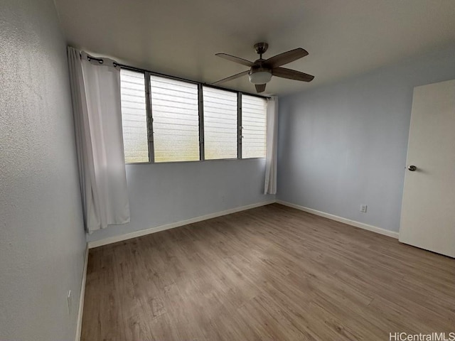 spare room with light wood-style flooring, baseboards, and ceiling fan