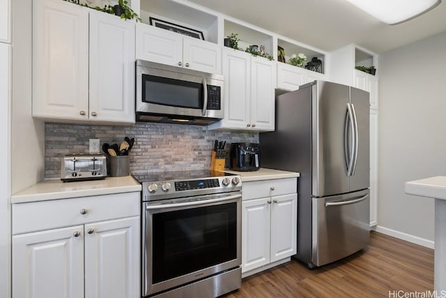 kitchen featuring tasteful backsplash, white cabinets, and appliances with stainless steel finishes