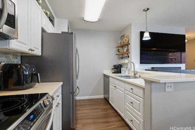 kitchen with a sink, dark wood-type flooring, appliances with stainless steel finishes, and white cabinetry