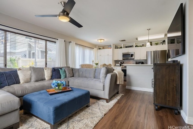 living room with dark wood finished floors, visible vents, and ceiling fan