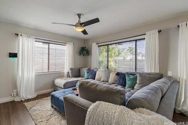 living area featuring wood finished floors, baseboards, and ceiling fan