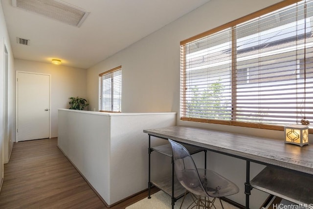 hall featuring an upstairs landing, visible vents, and wood finished floors