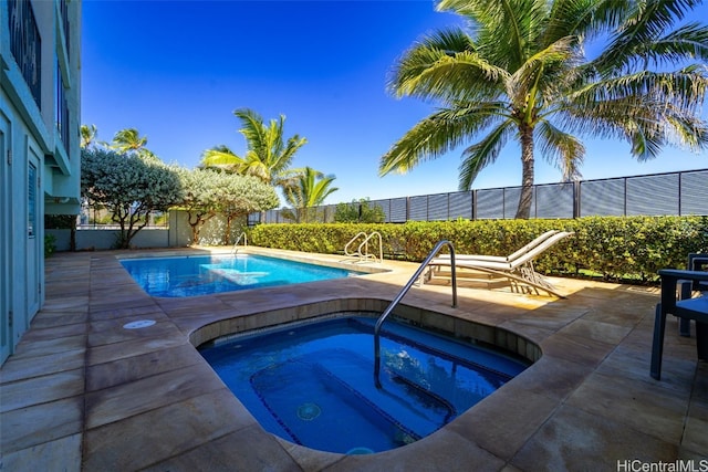 view of pool featuring an in ground hot tub, a patio area, fence, and a fenced in pool