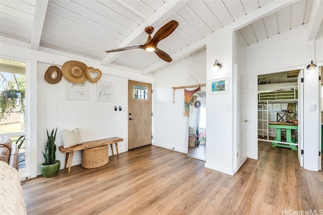 foyer with light wood-style flooring, a healthy amount of sunlight, and lofted ceiling with beams