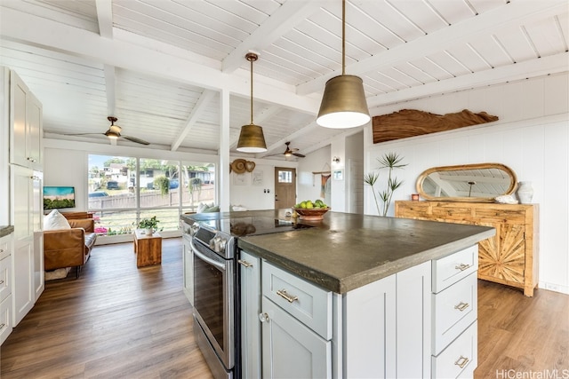 kitchen with dark countertops, open floor plan, light wood finished floors, stainless steel electric range oven, and vaulted ceiling with beams