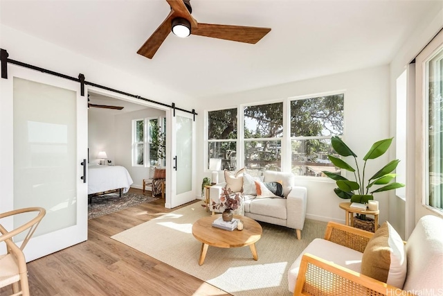 sunroom with ceiling fan and a barn door