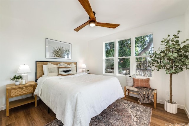 bedroom featuring ceiling fan, baseboards, and wood finished floors