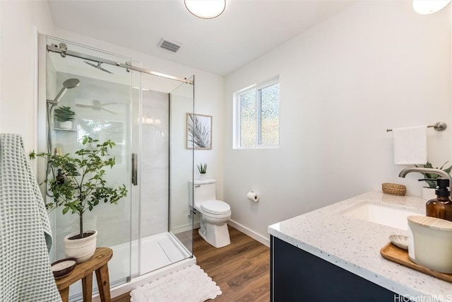 full bath with visible vents, a shower stall, toilet, and wood finished floors