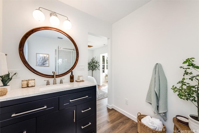 bathroom featuring vanity, wood finished floors, visible vents, and baseboards