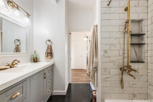 bathroom featuring tiled shower and vanity