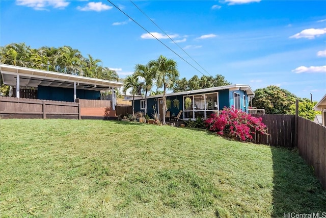 rear view of property featuring a yard and a fenced backyard