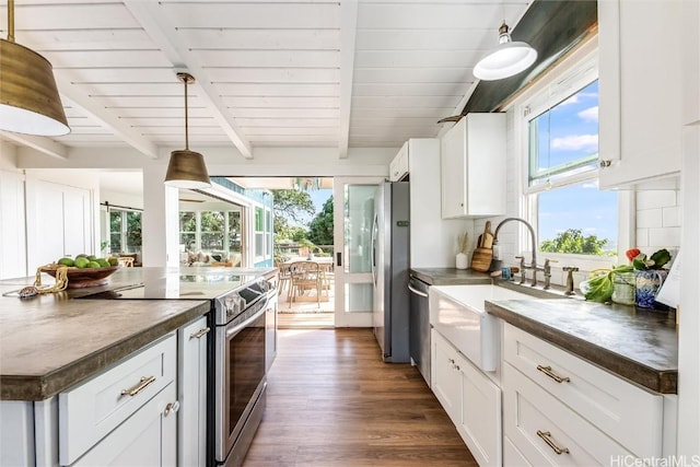 kitchen featuring a sink, dark countertops, beam ceiling, and stainless steel appliances