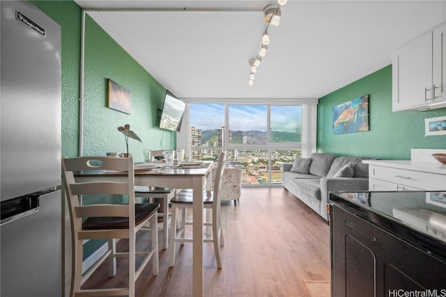2211 Ala Wai Blvd Unit 2414, Honolulu, HI 96815 - dining room with track lighting, light wood-style floors, a textured wall, and expansive windows