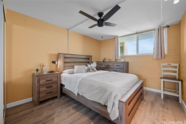 2211 Ala Wai Blvd Unit 2414, Honolulu, HI 96815 - bedroom with a ceiling fan, concrete block wall, wood finished floors, and baseboards