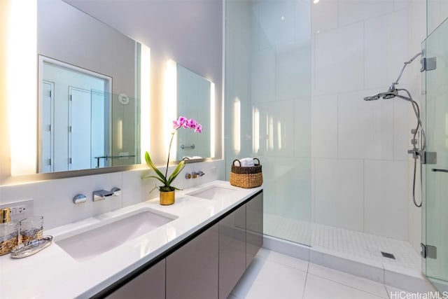 full bath with double vanity, tiled shower, and a sink