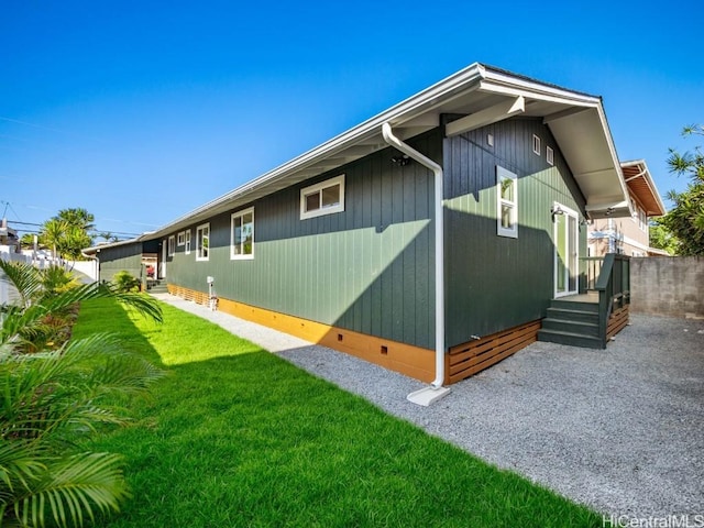 view of property exterior with crawl space, a yard, and fence