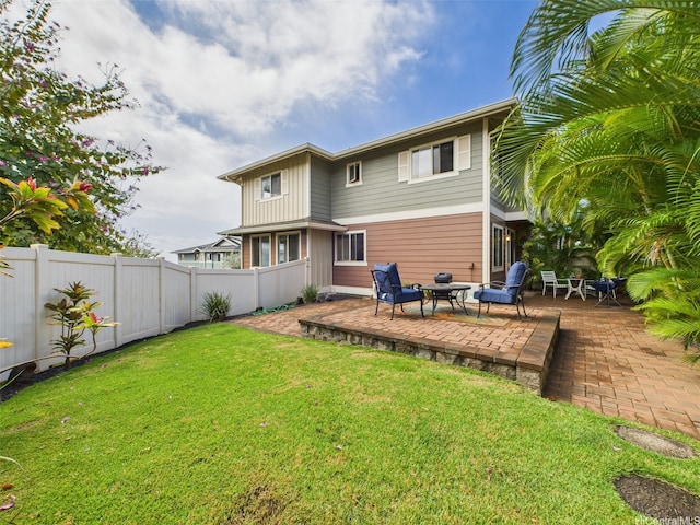 back of property with a patio, a yard, and a fenced backyard