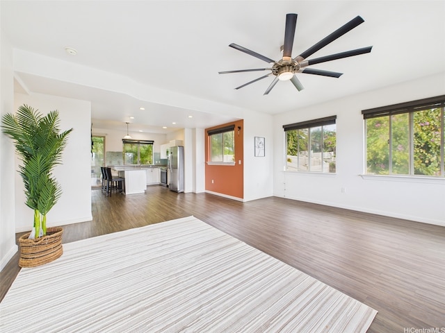 unfurnished living room with dark wood-style flooring, ceiling fan, recessed lighting, and baseboards