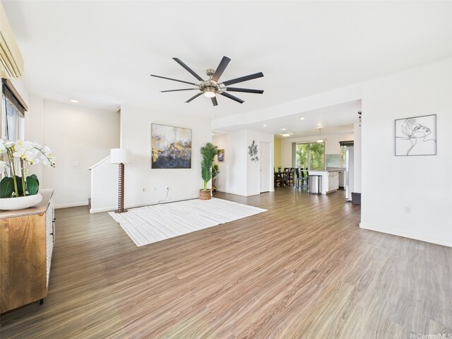 living room featuring wood finished floors, baseboards, a ceiling fan, and recessed lighting