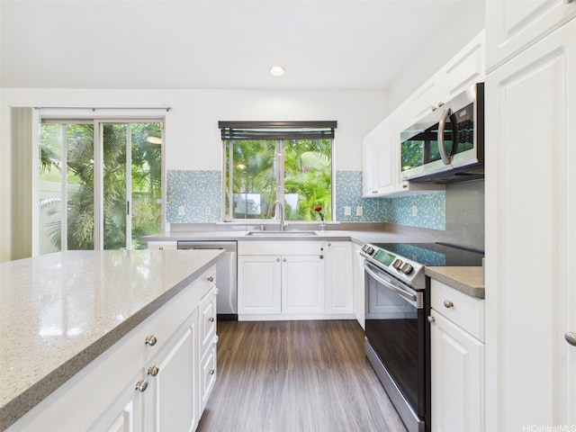 kitchen featuring a sink, white cabinets, decorative backsplash, and stainless steel appliances