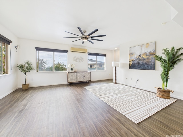 interior space with a wall mounted air conditioner, a wealth of natural light, wood finished floors, and ceiling fan