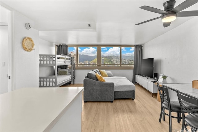 living room with a ceiling fan and light wood-type flooring