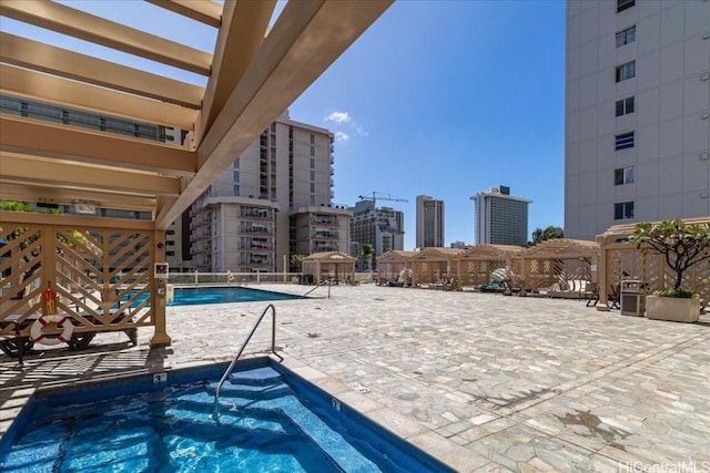 pool featuring a patio area, a view of city, and a pergola