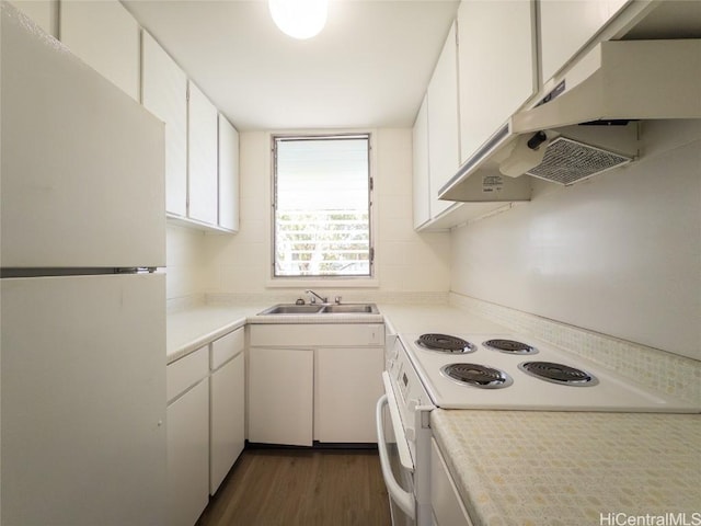 kitchen featuring white appliances, dark wood finished floors, light countertops, under cabinet range hood, and a sink