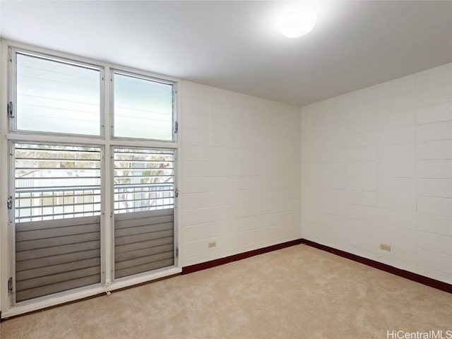 unfurnished room with carpet flooring and concrete block wall