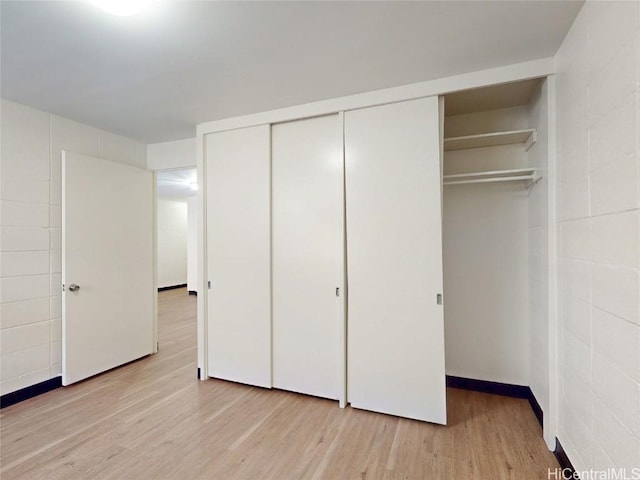 unfurnished bedroom with a closet and light wood finished floors