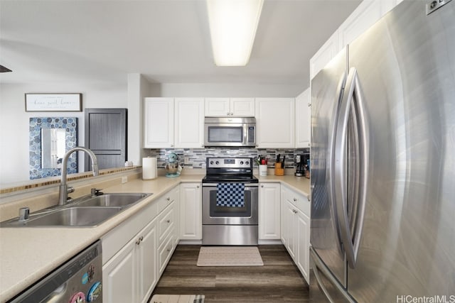 kitchen featuring stainless steel appliances, a sink, white cabinetry, and decorative backsplash