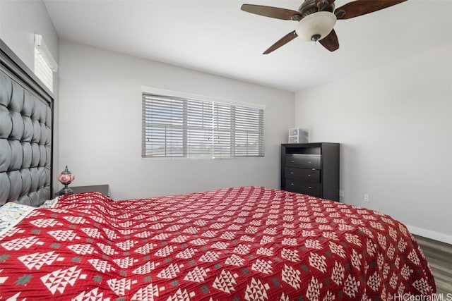 bedroom with ceiling fan, wood finished floors, and baseboards