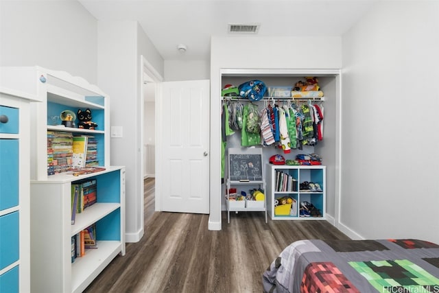 bedroom featuring dark wood-style flooring, a closet, and visible vents