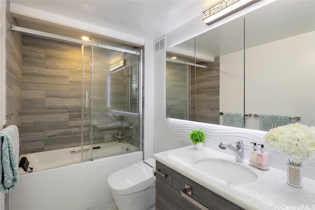 full bathroom with vanity, toilet, combined bath / shower with glass door, and visible vents