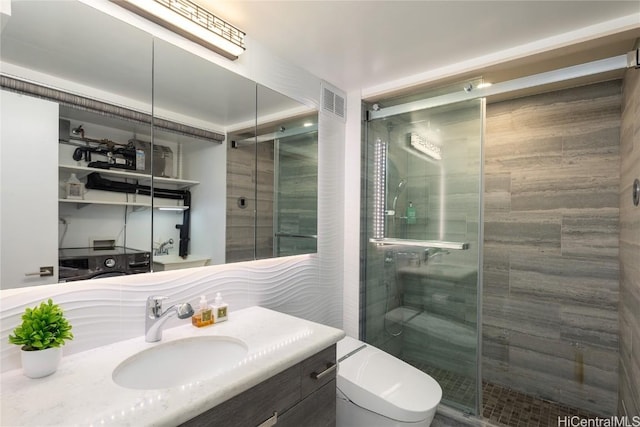 bathroom with visible vents, vanity, toilet, and a shower stall