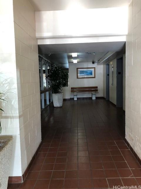 hall featuring dark tile patterned flooring