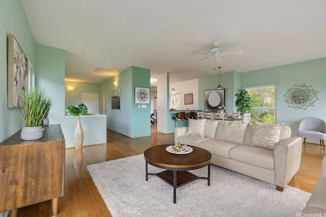 living area with ceiling fan and wood finished floors