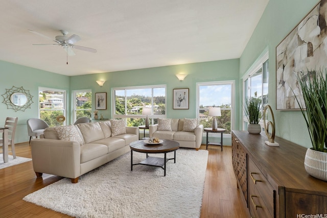living room with a healthy amount of sunlight, a ceiling fan, and wood finished floors