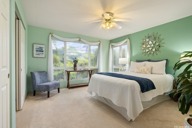 bedroom with a ceiling fan and light colored carpet