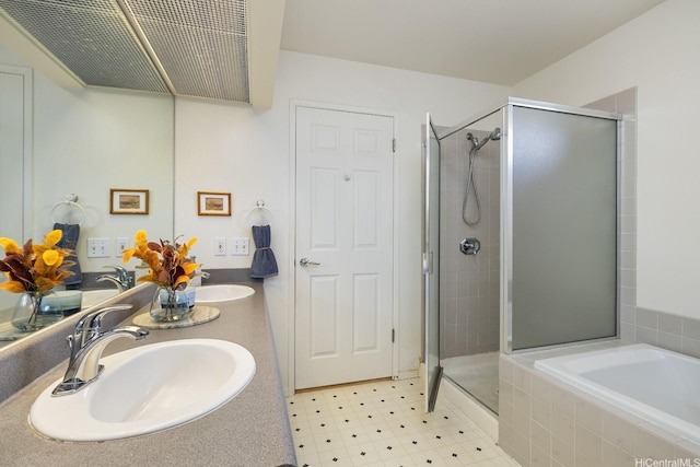 bathroom with double vanity, a shower stall, a sink, and a bath