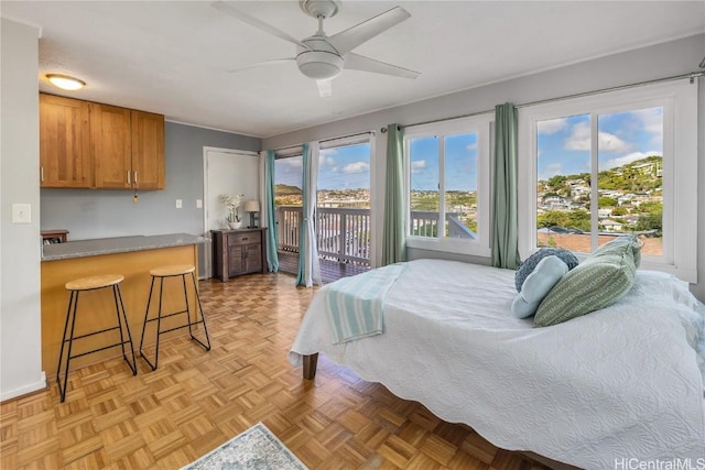 bedroom with multiple windows, ceiling fan, and access to outside