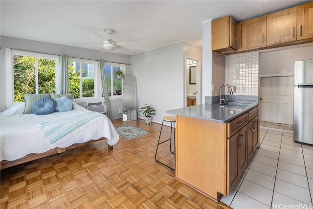 bedroom featuring ornamental molding, cooling unit, freestanding refrigerator, and a sink