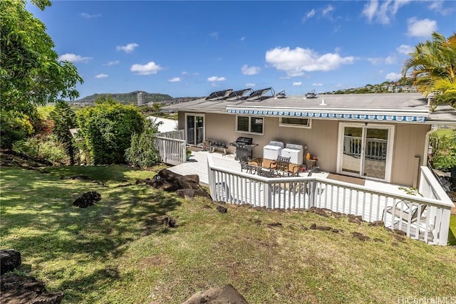 rear view of property with a lawn, an outdoor hangout area, and a wooden deck