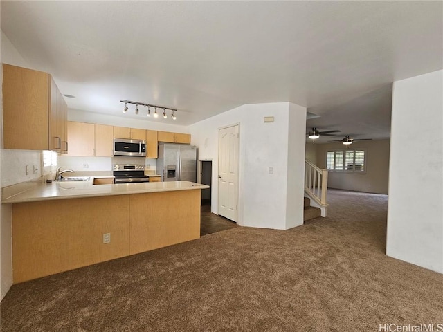 kitchen featuring a peninsula, open floor plan, light countertops, appliances with stainless steel finishes, and dark carpet